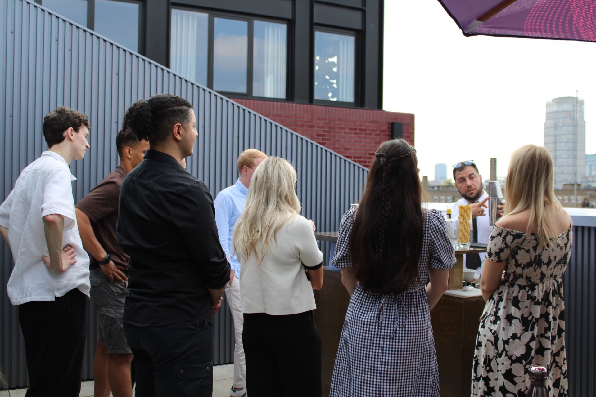 Mixologist teaching cocktail making to a group of guests